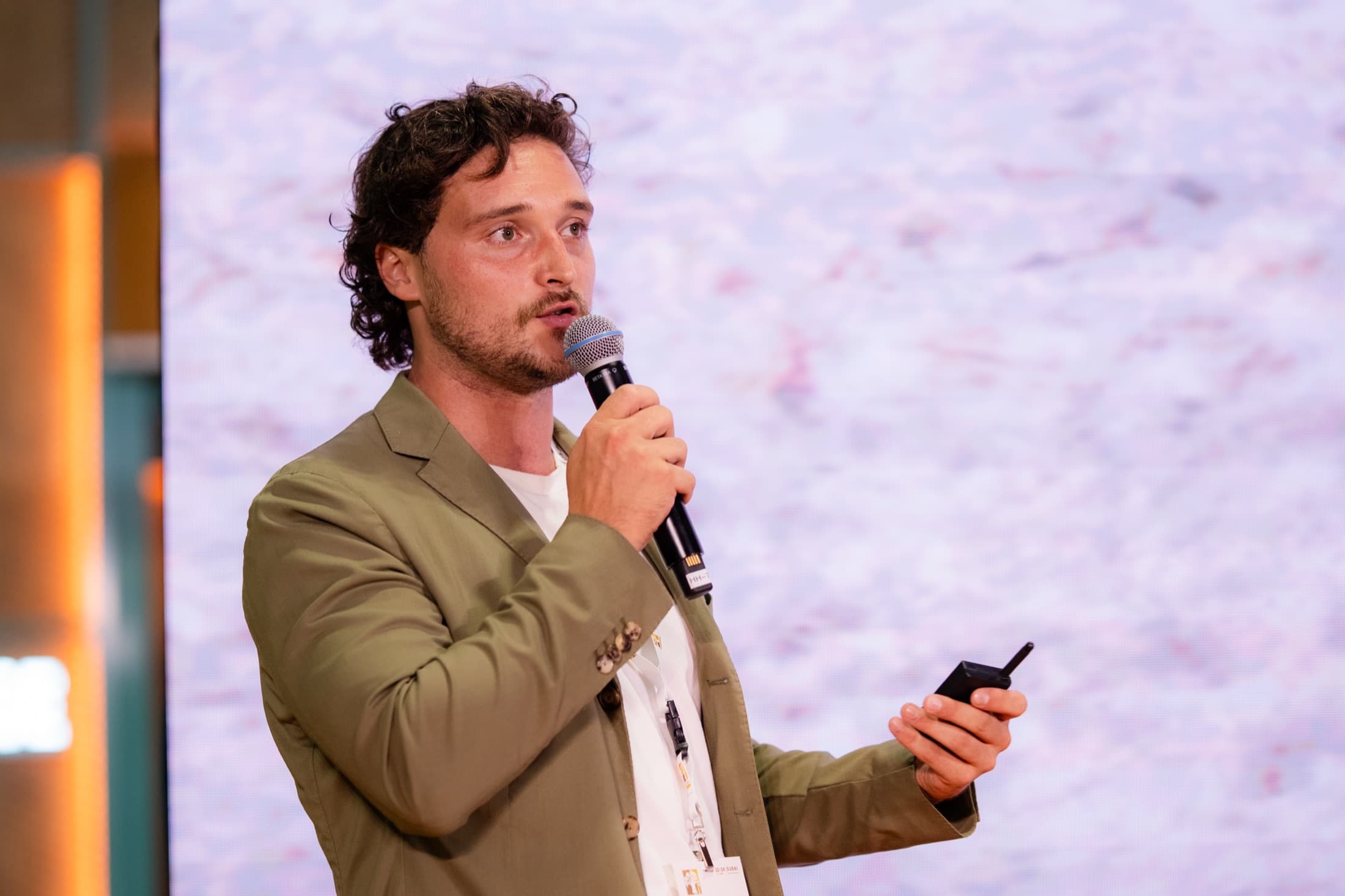 Andy Cartier speaking on stage in a green jacket at Dubai WoodShow in June 2026