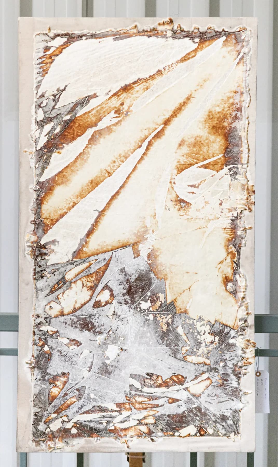 Vertical panel with sweeping rust and ochre diagonal strokes over white, and a dense silver-grey textured zone at the bottom.