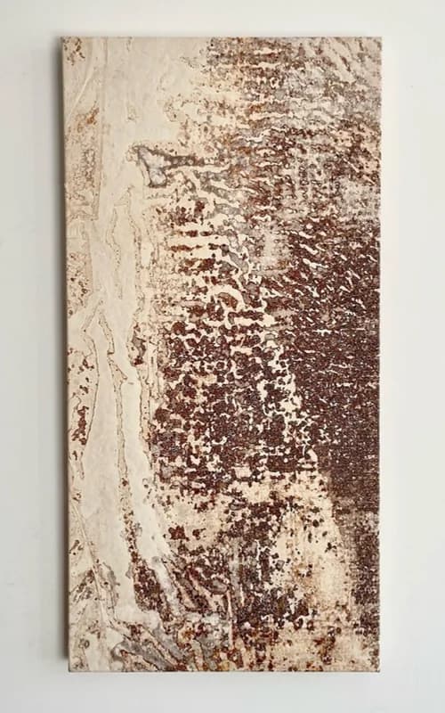 Vertical panel, cream on the left and densely speckled in red-brown on the right, hung on a white wall.