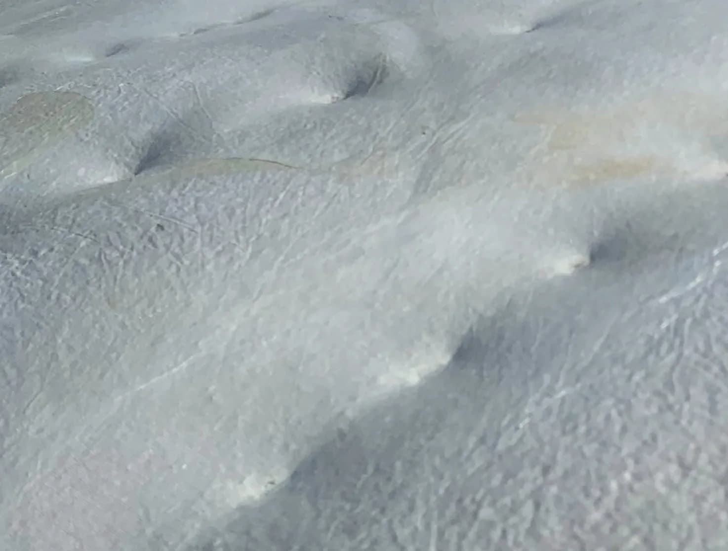Close-up of a soft white grown surface with gentle quilted dimples.